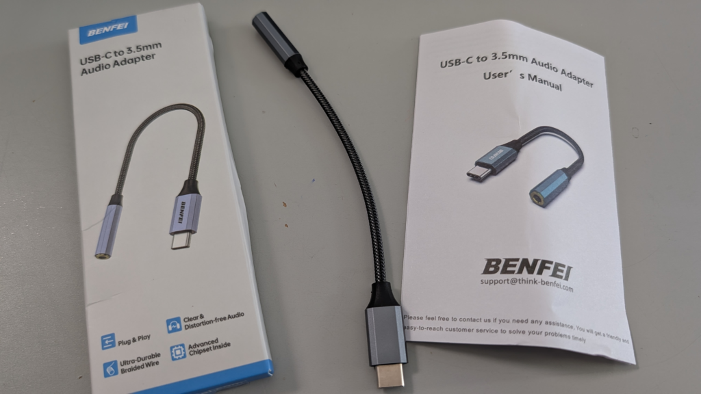Unboxing of the BENFEI USB-C DAC Adapter with the adapter and its packaging displayed on a desk.