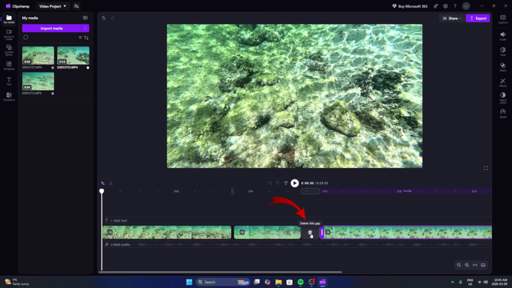 Screenshot of Microsoft Clipchamp in Windows 11 showing two underwater snorkeling clips with a black gap between them on the timeline. A red arrow points to the trash can icon inside the gap with a tooltip that says "Delete this gap". 🗑️