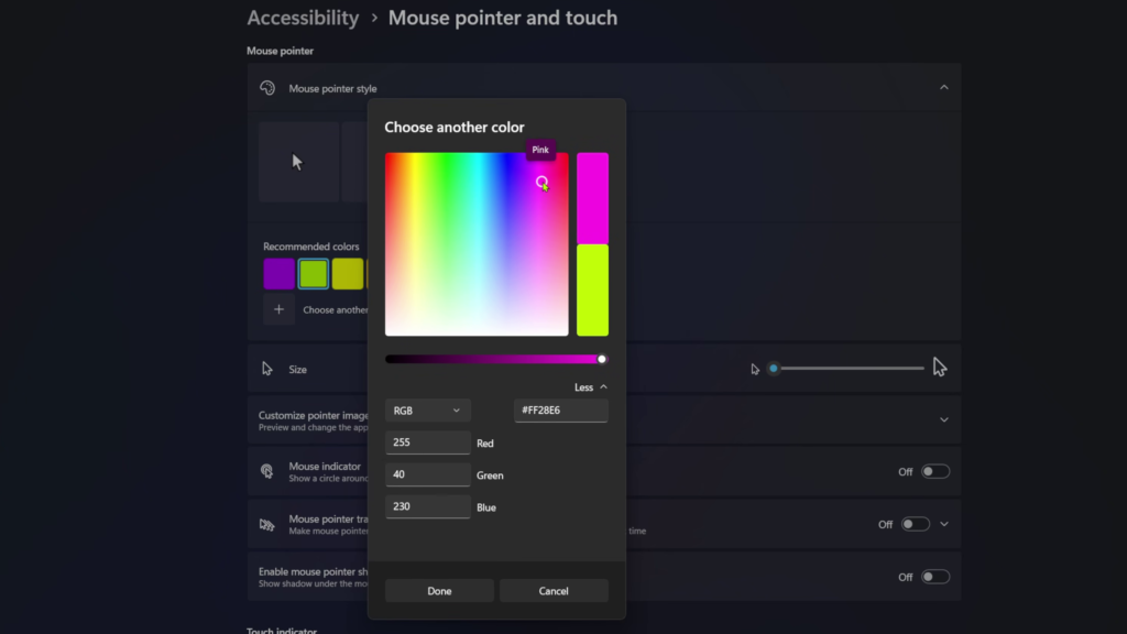 A screenshot of the Windows 11 Accessibility settings menu for Mouse pointer and touch. A "Choose another color" window is open, showing a full rainbow color spectrum, an RGB color code input box set to pink, and a size adjustment slider in the background.